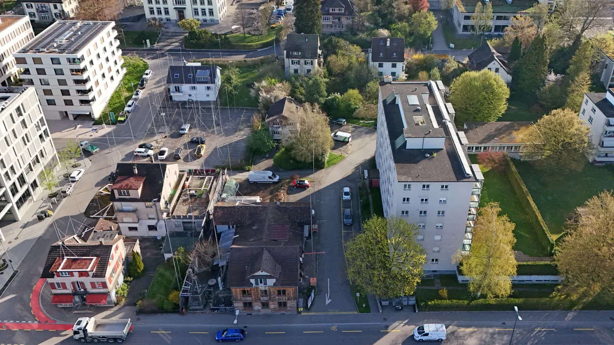Blick aus der Luft auf das Gestaltungsplangebiet Pestalozzistrasse mit niedrigen Bauten links und in der Mitte und rechts einem siebengeschossigen Wohnblock.
